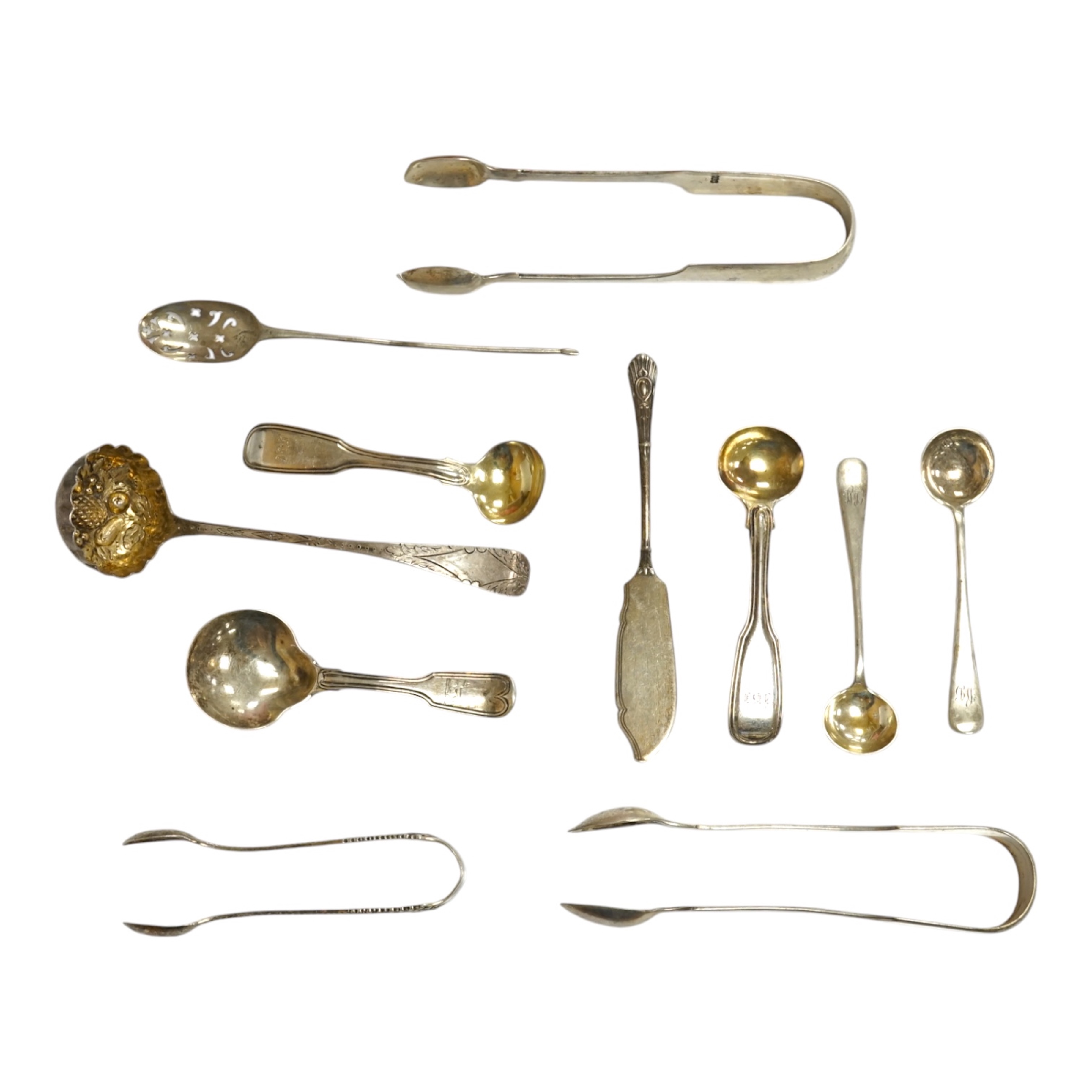 Ten assorted items of silver flatware including a mid 18th century mote spoon by Elizabeth Jackson?, 14.8cm, a George IV caddy spoons, two pairs of sugar tongs, four condiment spoons, a butter knife and sauce ladle, 6.8o